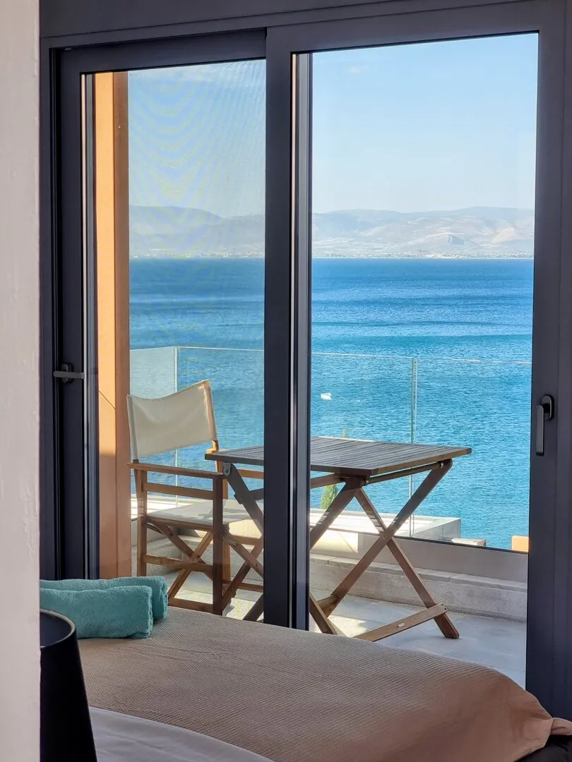 Balcony of Eos with a director’s chair facing the blue gulf