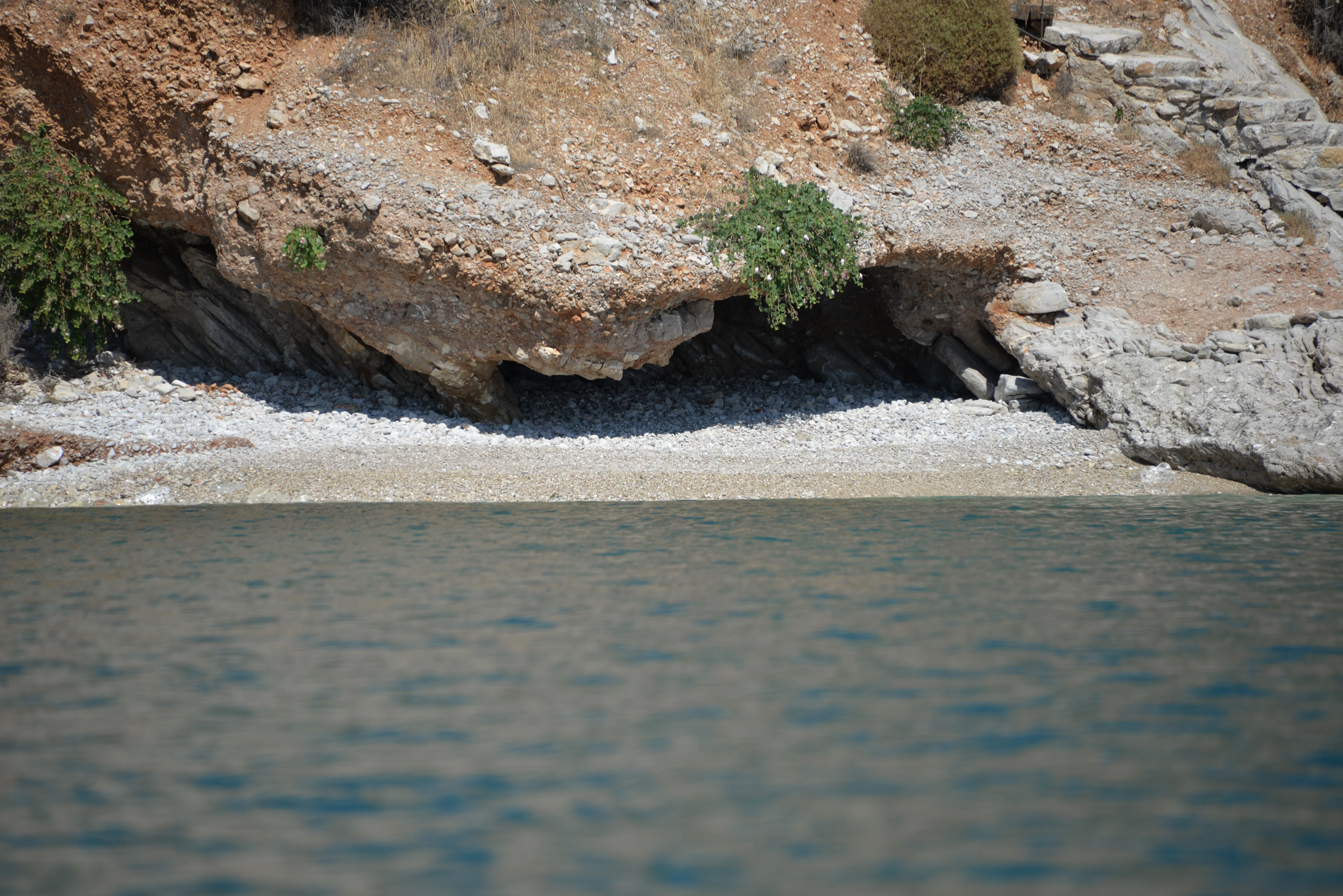 Quiet pebble cove beneath a limestone cliff