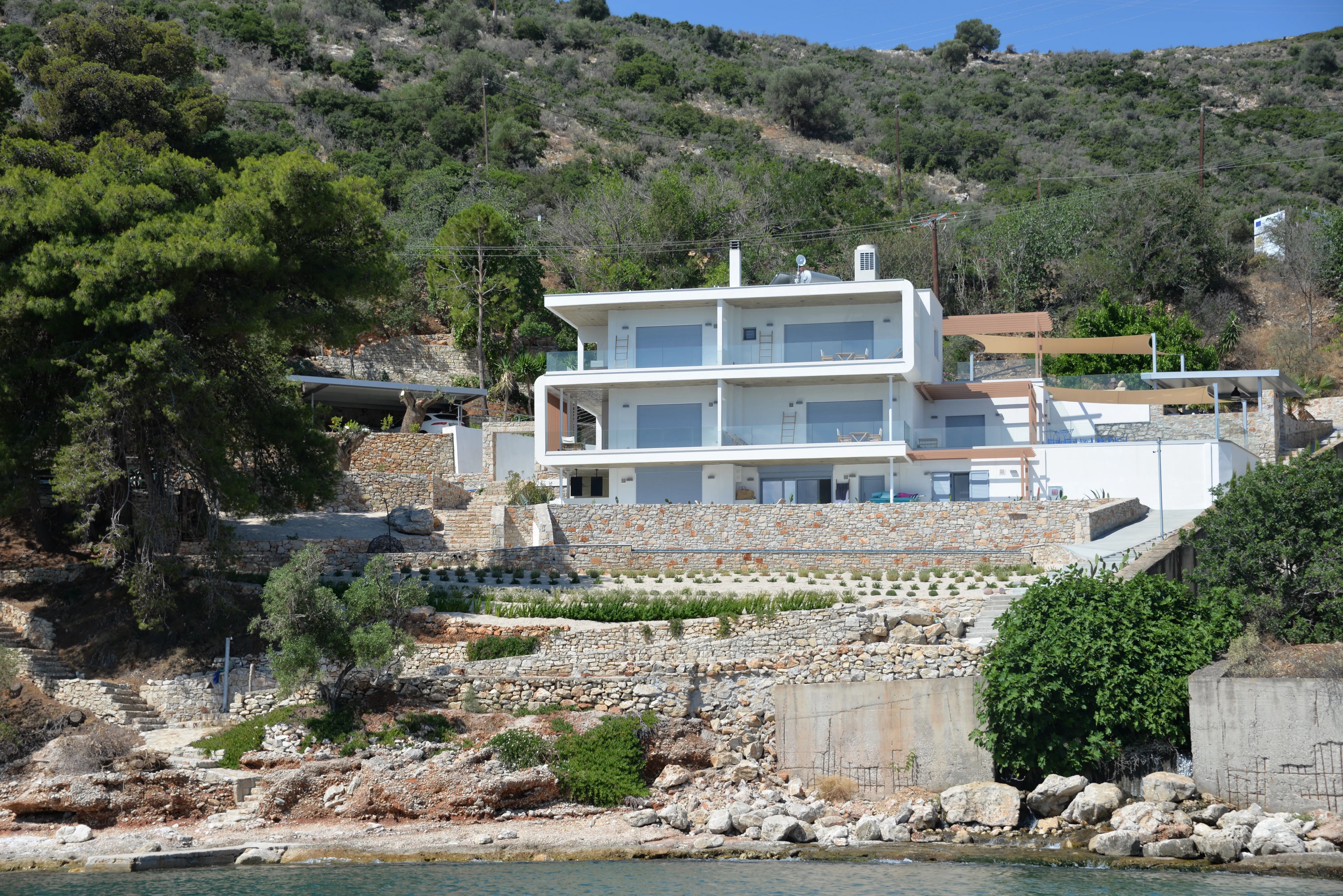 The white terraced building of Anavalos on the coastline, seen from the water