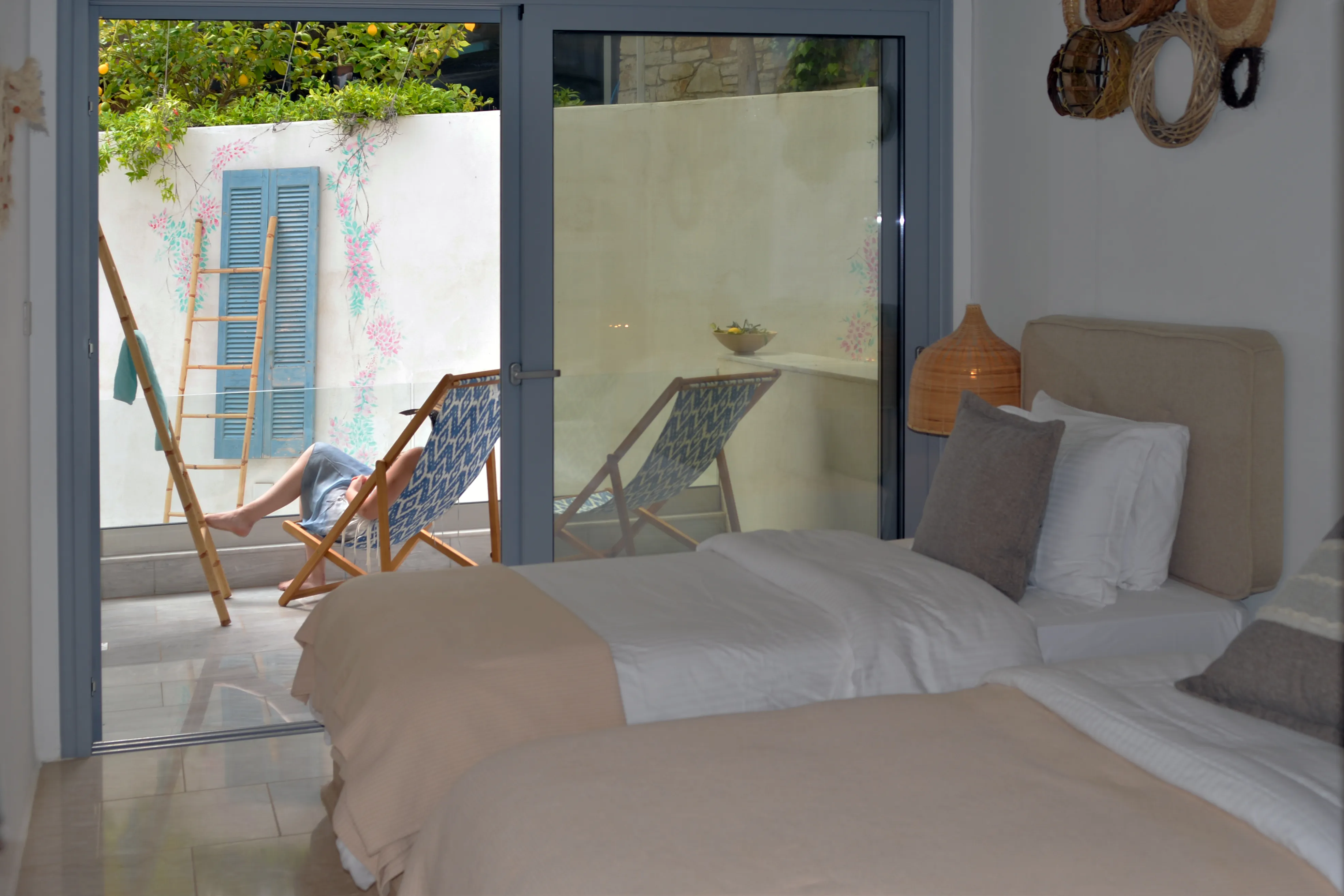 Second bedroom of Zephyros with twin beds and balcony deckchairs outside