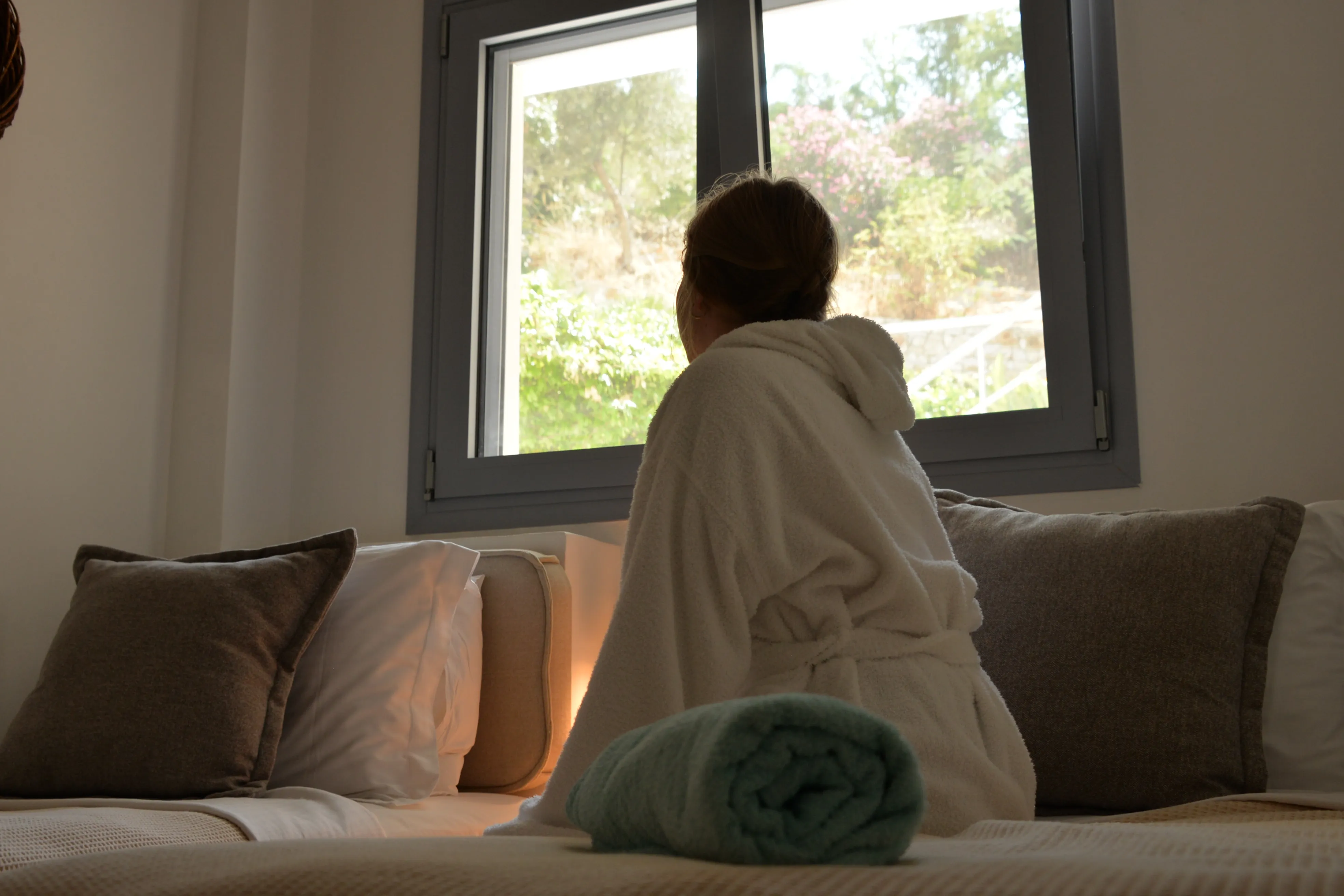 Guest at the window seat with a rolled green towel