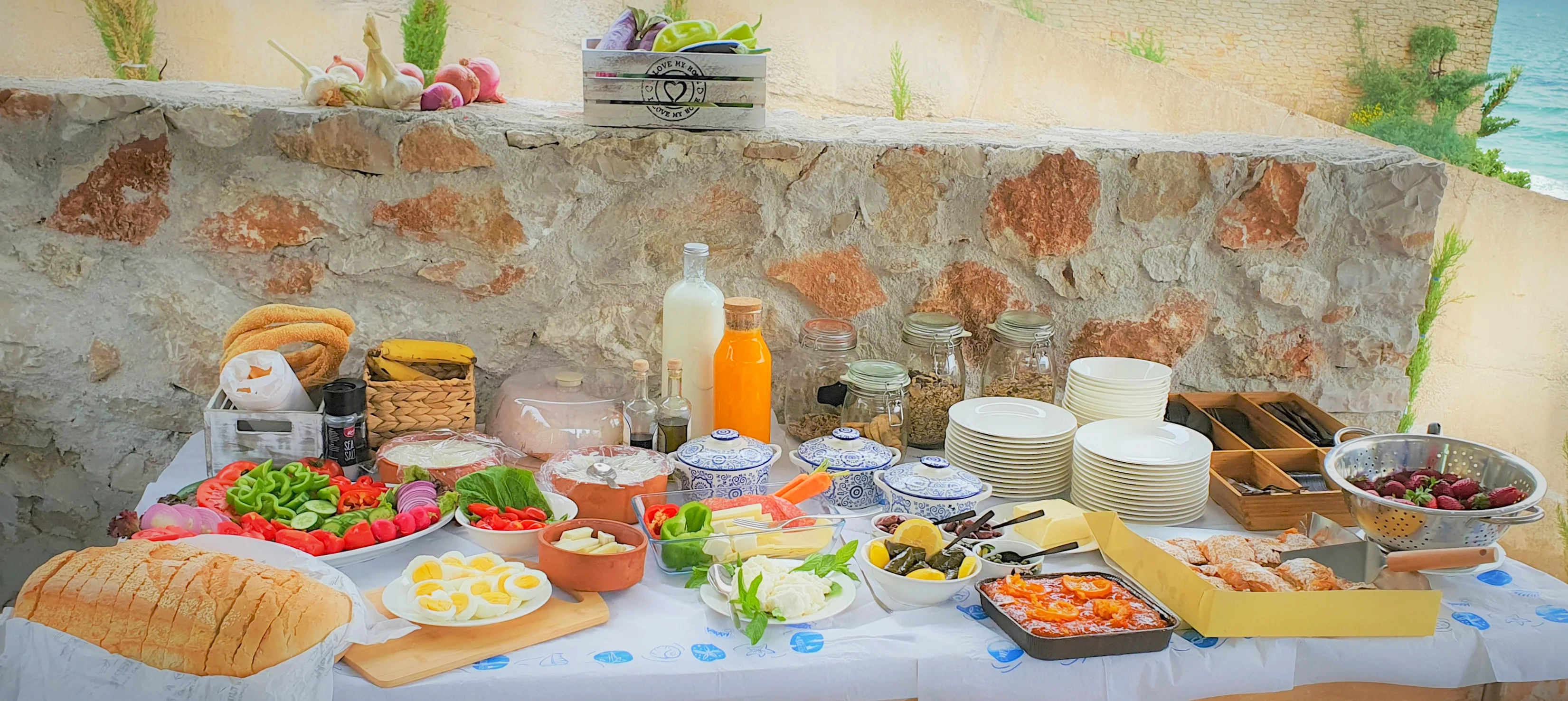 Breakfast buffet with fruit, eggs and local products against the stone wall