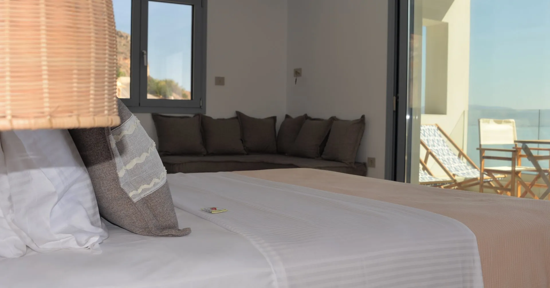 Kaikzas bed and corner sofa opening to the balcony above the sea